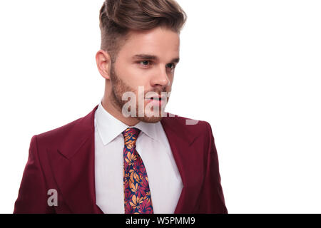 portrait of surprised man in grena suit looking down to side with mouth open Stock Photo
