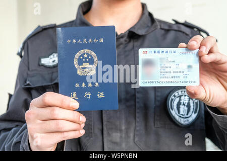A police officer shows the passport-shaped travel pass for use between the Chinese mainland and Hong Kong or Macao in Beijing, China, 6 May 2019.   Th Stock Photo