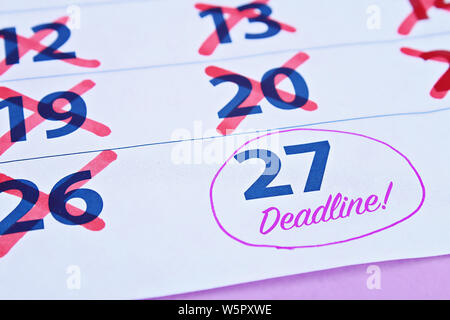 Deadline word written on the calendar. Calendar with deadline and crossed out days. Procrastination. Putting things off until later. Stock Photo