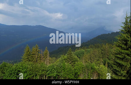 Beautiful panorama of mountains with real rainbow after the rain. Scenic nature background Stock Photo