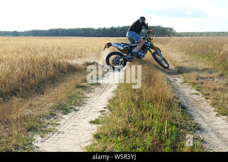 man on country road riding cross motorbike in Poland Stock Photo