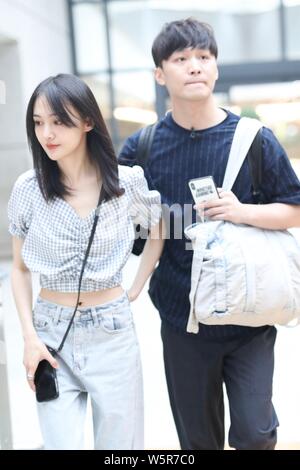 Chinese actress Zheng Shuang, left, and her boyfriend arrive at the Shanghai Hongqiao International Airport before departure in Shanghai, China, 19 Ju Stock Photo