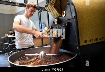 Berlin, Germany. 16th July, 2019. Philipp Reichel fills coffee 9 with the roasted coffee beans from the coffee roaster. Small roasting plants with a more differentiated view of Germany's favourite drink are enjoying ever greater popularity. (for dpa: '800 flavors per bean - How regional roasters mix up the market') Credit: Britta Pedersen/dpa-Zentralbild/dpa/Alamy Live News Stock Photo