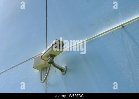 Closeup of cctv camera fixed to the wall outside of a building, safety concept Stock Photo