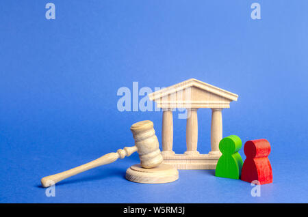 Two figures of people opponents stand near the courthouse and the judge's gavel. The judicial system. Conflict resolution in court, claimant and respo Stock Photo