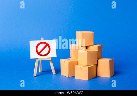 A stack pile cardboard boxes and a sign stand with red symbol NO. Restriction on the importation of goods, proprietary for business. Embargo, trade wa Stock Photo
