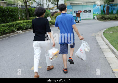 Local residents use QR code cards to open different bins to put their garbage at a waste collection point in Shanghai, China, 19 June 2019.   Shanghai Stock Photo