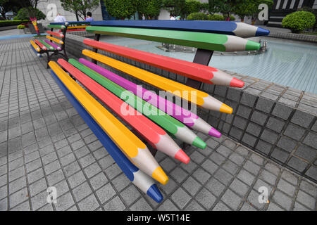 Colored pencil benches are pictured at a square amongst office buildings in  Guangzhou city, south China's Guangdong province, 23 June 2019. A square  amongst a cluster of high-rise office buildings in China's