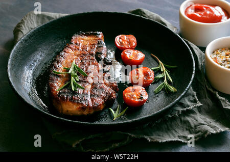 Barbecue pork steak in frying pan, close up Stock Photo