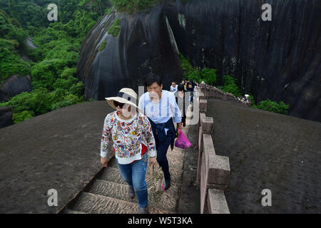 Tourists view the Zhai-type Danxia landforms at the Feitian Mountain ...