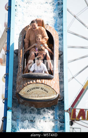 Hot weather in Skegness. People on the log water flume on Skegness beach. PICTURE TAKEN FROM A PUBLIC PLACE Stock Photo