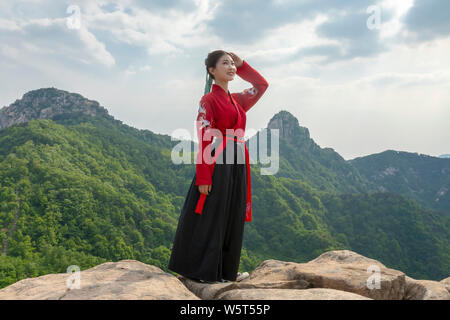 --FILE--A Chinese girl dressed in traditional costumes poses at the Yimeng Mountain in Weifang city, east China's Shandong province, 19 May 2019. The Stock Photo