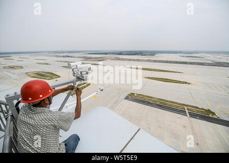 A Chinese worker is seen at the air traffic control tower, known as the 'Eye of Phoenix', at the Beijing Capital International Airport in Beijing, Chi Stock Photo