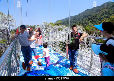 Chinese tourists walk on Guangdong's longest glass-bottomed bridge at the Nandan Mountain in Foshan city, south China's Guangdong province, 20 Decembe Stock Photo