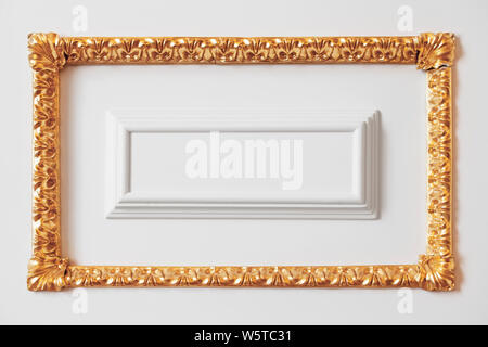 Classic luxury interior fragment, white wall decoration element with carved golden frame Stock Photo