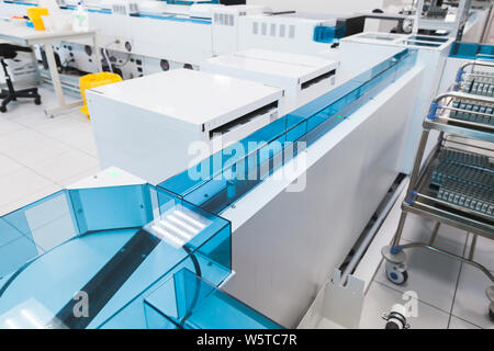 Blood samples move on the tray of pre-analytical system in clinical laboratory. Blood bank, fully automated equipment Stock Photo