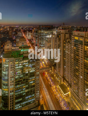 A night view of the busy roads with masses of vehicles through high-rise office and residential apartment buildings in the Central Business District ( Stock Photo