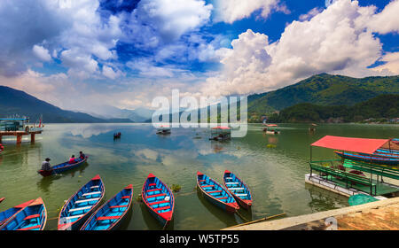 Beautiful View of Phewa Lake and colorful boats with blue sky on the background Pokhara Nepal Stock Photo