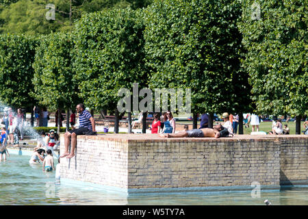 23/07/2019. Battersea, London, UK. People play in the water fountains in Battersea Park in London during a heatwave across the UK. Stock Photo