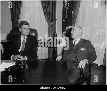 Photograph of President John F. Kennedy conferring with former President Harry S. Truman in the Oval Office, on Kennedy's first full day in the White House. Stock Photo