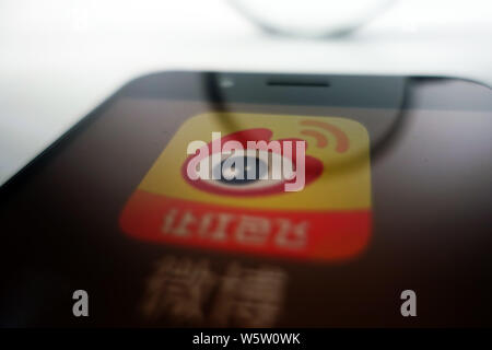 --FILE--A Chinese netizen looks at a logo of Weibo, the Twitter-like microblogging service of Chinese Internet portal Sina, on his smartphone in Ji'na Stock Photo