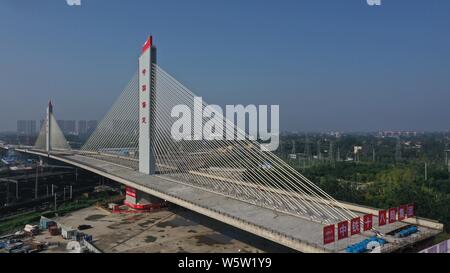 (190730) -- BAODING, July 30, 2019 (Xinhua) -- This aerial photo taken on July 30, 2019 shows two parts of a bridge above the Beijing-Guangzhou Railway after they are successfully rotated to their targeted positions using the swivel construction method in Baoding, north China's Hebei Province. China has adopted the swivel construction method in building many bridges to minimize the interference on the traffic below. The method helps overcome the constraints of environment and traffic, while shortening the construction period. (Photo by Wang Huitang/Xinhua) Stock Photo