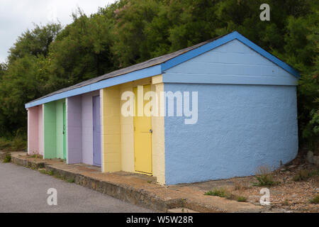 Brightly painted concrete beach huts in Folkestone Kent Stock Photo