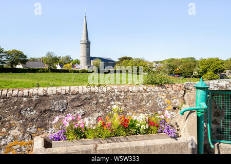 Flowers in an old water trough next to a pump in Torteval, Guernsey, Channel Islands UK Stock Photo