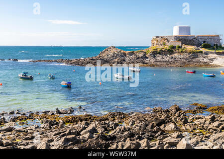 Fishing boats in front of Fort Grey, a Martello Tower built in 1804 in Rocquaine Bay, Guernsey, Channel Islands UK Stock Photo