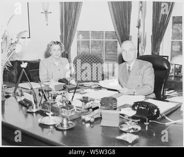 Photograph of President Truman and his secretary, Rose Conway, at the President's desk in the Oval Office. Stock Photo