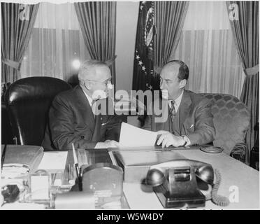 Photograph of President Truman at his desk in the Oval Office with Governor Adlai E. Stevenson of Illinois, the defeated Democratic candidate for President in the 1952 election. Stock Photo