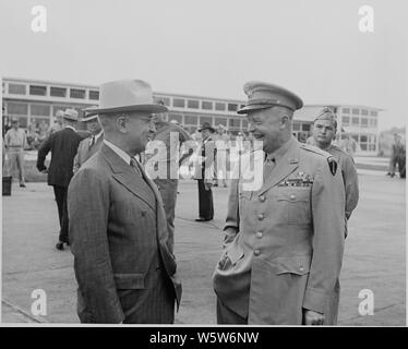 Photograph of President Truman laughing and chatting with General Dwight D. Eisenhower at the National Airport in Washington, as the President prepares to leave for a trip to the West Coast. Stock Photo