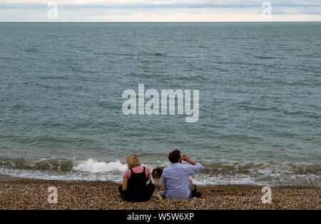 Couple with their dog on Sandgate beach in Kent near Folkestone England Stock Photo