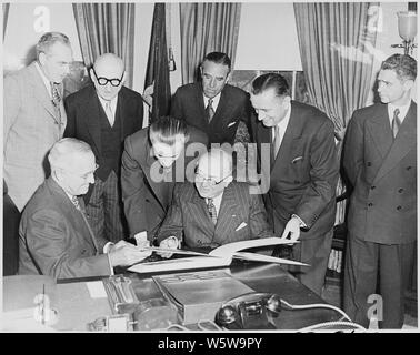 Photograph of President Truman with French President Vincent Auriol in the Oval Office, as President Auriol examines a book containing photographs of monuments given to the United States by France, presented to him by Secretary of the Interior Oscar Chapman; (standing. left to right) Secretary of State Dean Acheson, French Foreign Minister Robert Schuman, French Ambassador Henri Bonnet, Special Assistant to the President Averell Harriman, Secretary Chapman, and an unidentified man. Stock Photo