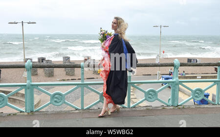 Brighton, UK. 30th July, 2019. Hannah Goldsmith celebrates graduating from the University of Brighton on a windy seafront after the ceremony . Credit: Simon Dack/Alamy Live News Stock Photo
