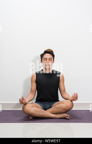Young black man practicing yoga lesson with instructor, sitting in Sukhasana exercise Stock Photo
