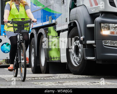 Berlin, Germany. 30th July, 2019. A cyclist drives next to a truck. Berliner Wasserbetriebe is presenting three of its 88 trucks retrofitted with turn-off assistants. Credit: Annette Riedl/dpa/Alamy Live News Stock Photo
