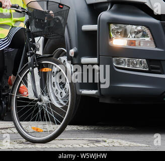 Berlin, Germany. 30th July, 2019. A cyclist drives next to a truck. Berliner Wasserbetriebe is presenting three of its 88 trucks retrofitted with turn-off assistants. Credit: Annette Riedl/dpa/Alamy Live News Stock Photo