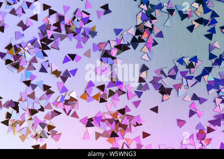 Abstract background of multicolored confetti in neon light. Selective focus. Stock Photo