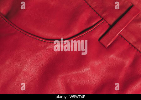 Red leather clothes texture. Stitched material with pocket. Front side with copy space. Closeup texture background. Stock Photo