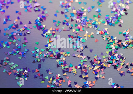 Abstract background of multicolored confetti in neon light. Selective focus. Stock Photo