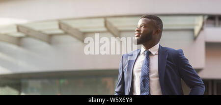 African businessman looking away standing in front of office building Stock Photo