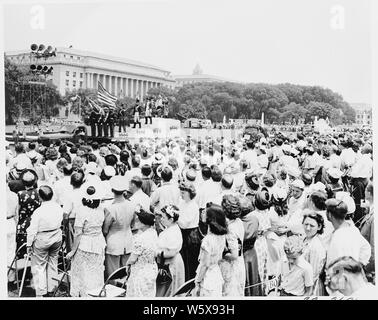President Truman attends ceremonies celebrating the 100th anniversary of the Washington Monument. This view shows the crowd watching the parade.