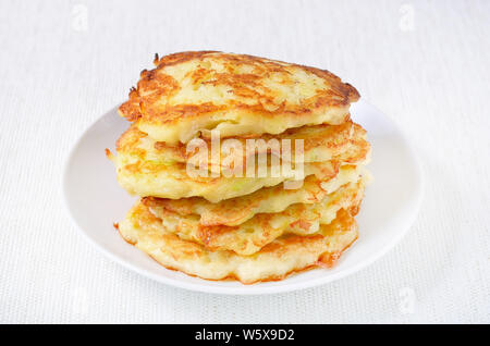 Fried courgette pancakes on white plate Stock Photo