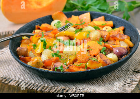 Pumpkin stew with vegetables on rustic table Stock Photo