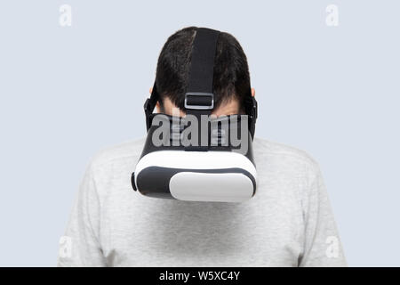 Young man using vr headset in studio, experiencing virtual reality Stock Photo