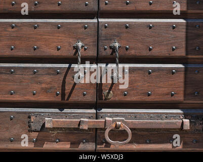 rusted bolt on old wooden door with iron studs Stock Photo