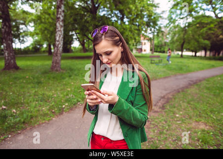 Young woman receiving a disturbing message on her phone Stock Photo