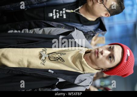 Chinese actor Dylan Wang Hedi, center, of the new lineup of Chinese boy group F4 is surrounded by crowds of fans as he arrives at an airport in Shangh Stock Photo