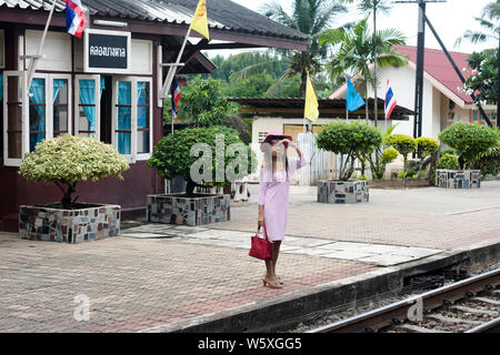 Thailandese woman waiting for her train in Kanchanaburi, Thailand. Stock Photo